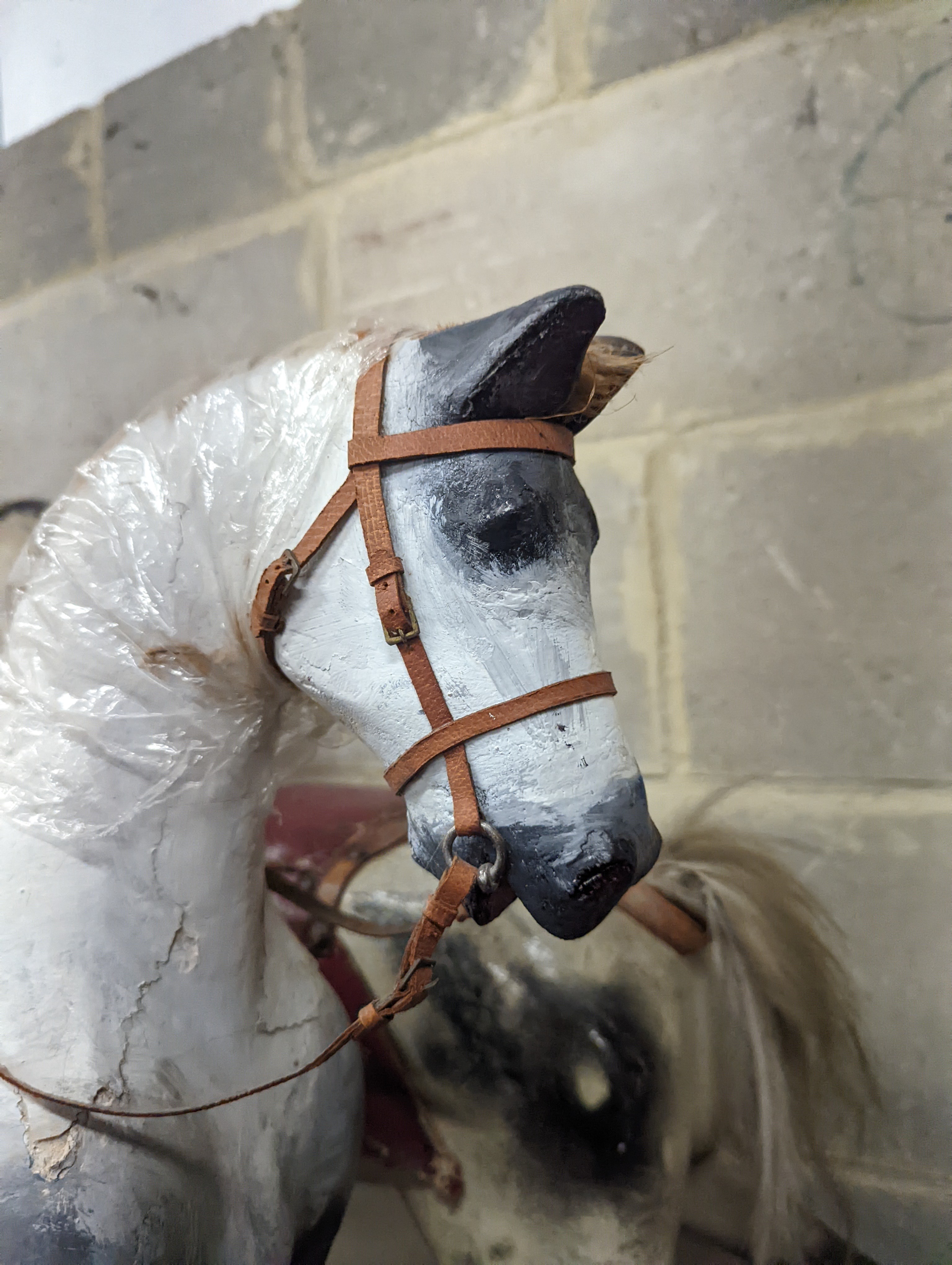 A Victorian carved and painted wood rocking horse, lacking underframe, length 77cm and two painted wood hobby horses, 58cm and 38cm